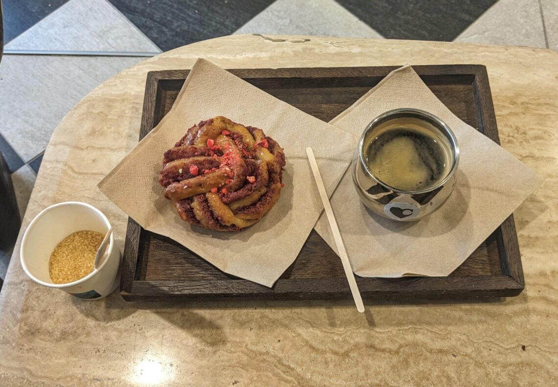 Février 2026 - Une pâtisserie aux pralines roses et du café sur un plateau