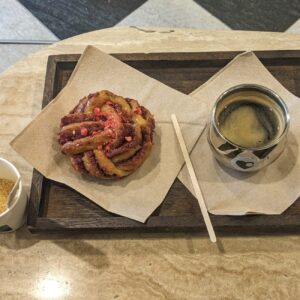 Février 2026 - Une pâtisserie aux pralines roses et du café sur un plateau